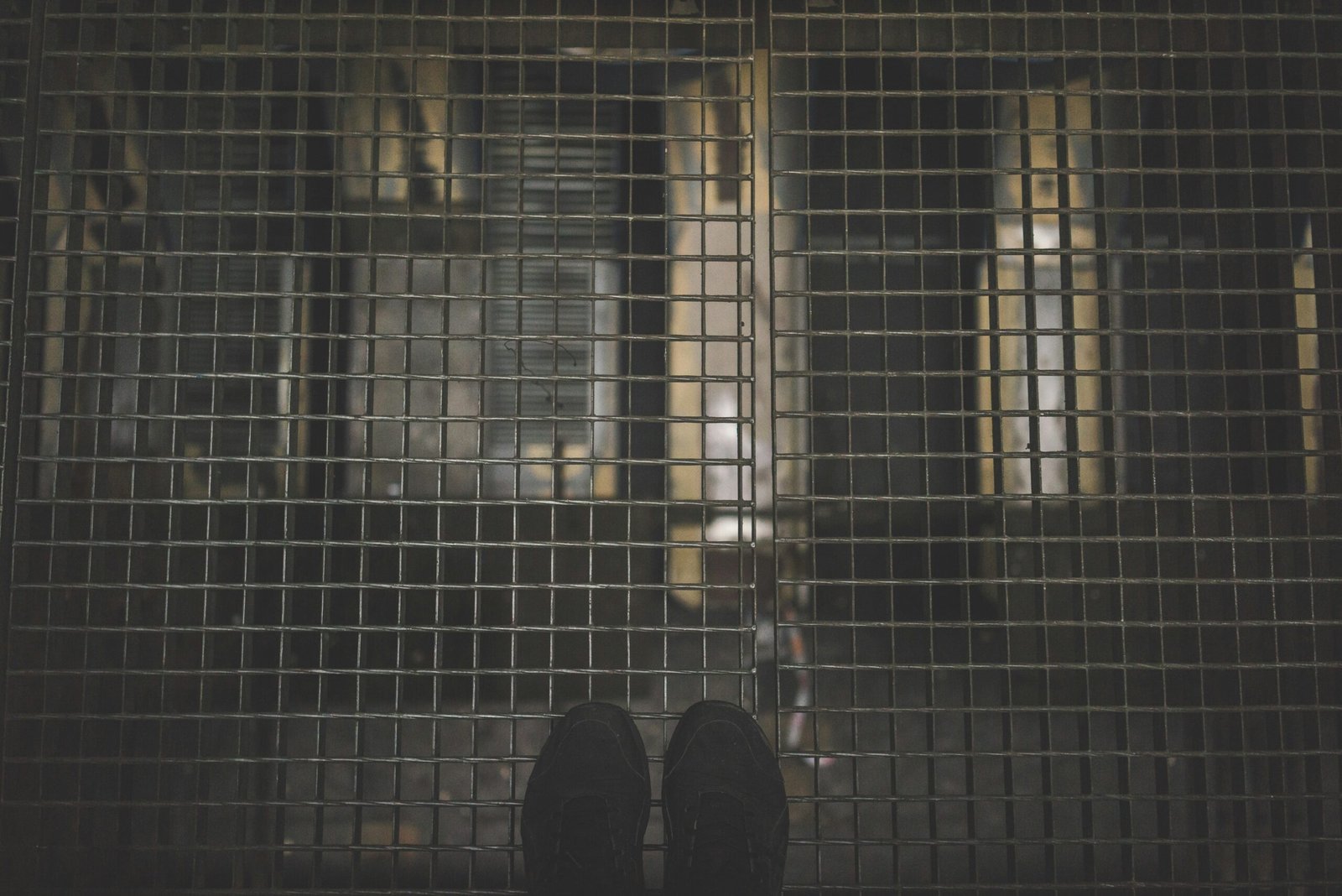 person standing on gray mesh surface